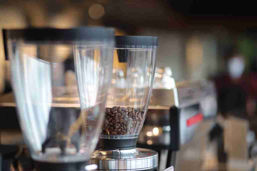 Coffee grinder hoppers filled with roasted beans in a cafe